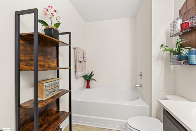 bathroom with toilet, a bath, and vanity