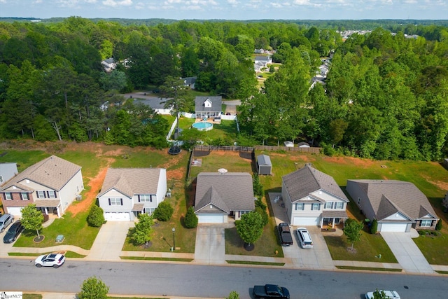 bird's eye view featuring a wooded view and a residential view