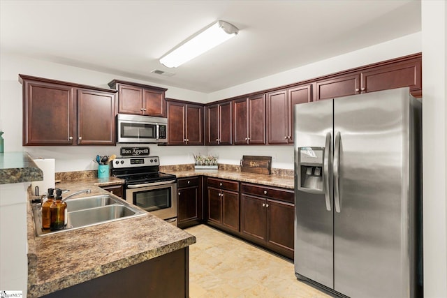 kitchen with a sink, appliances with stainless steel finishes, dark brown cabinetry, and visible vents