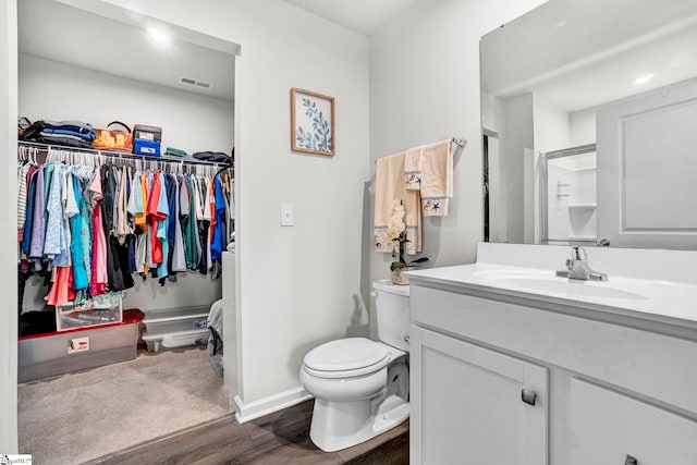 124 Highland Station Dr, Clinton, SC 29325 - full bathroom featuring wood finished floors, vanity, toilet, a walk in closet, and baseboards