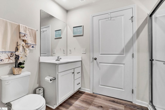 124 Highland Station Dr, Clinton, SC 29325 - bathroom with wood finished floors, vanity, toilet, and a shower with door