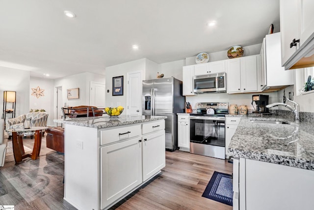 124 Highland Station Dr, Clinton, SC 29325 - kitchen with appliances with stainless steel finishes, a sink, a center island, white cabinets, and light wood-type flooring
