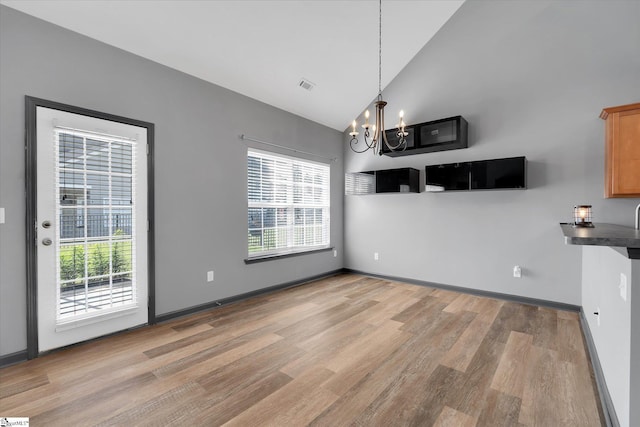unfurnished dining area with plenty of natural light, light wood-type flooring, visible vents, and a notable chandelier