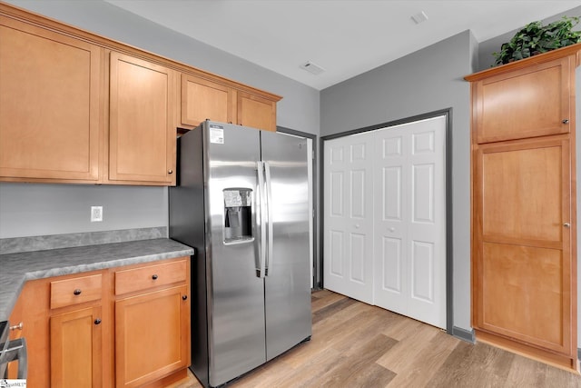 kitchen with light wood-type flooring, visible vents, and stainless steel fridge with ice dispenser