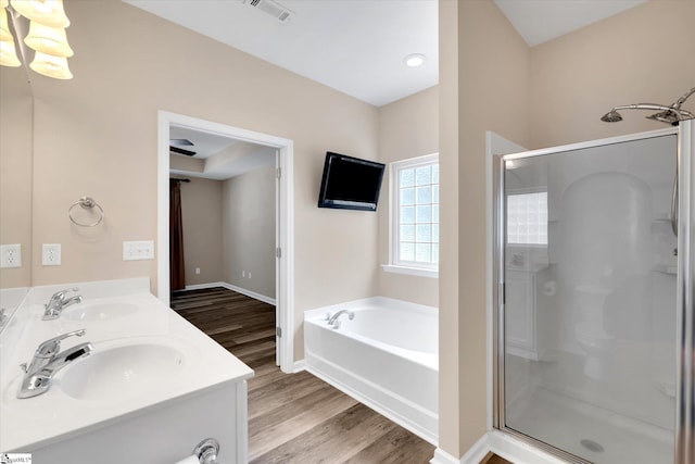 bathroom with visible vents, a sink, a garden tub, and a stall shower