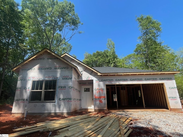 unfinished property with driveway and a garage
