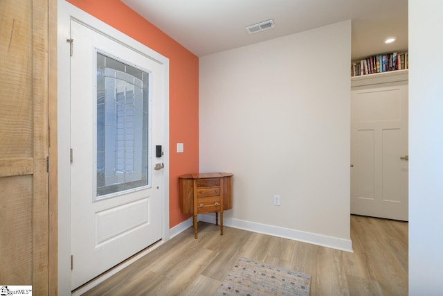 doorway featuring visible vents, light wood-style flooring, and baseboards