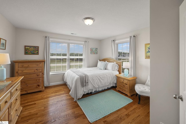 327 Terra Plains Dr, Greer, SC 29651 - bedroom featuring visible vents, a textured ceiling, light wood-style flooring, and baseboards