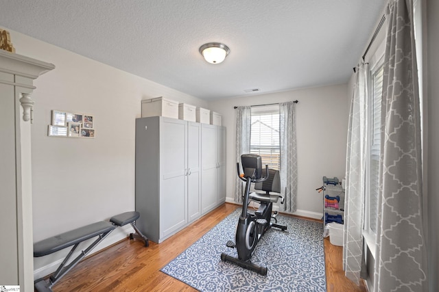 327 Terra Plains Dr, Greer, SC 29651 - exercise room featuring light wood-style floors, a textured ceiling, baseboards, and visible vents