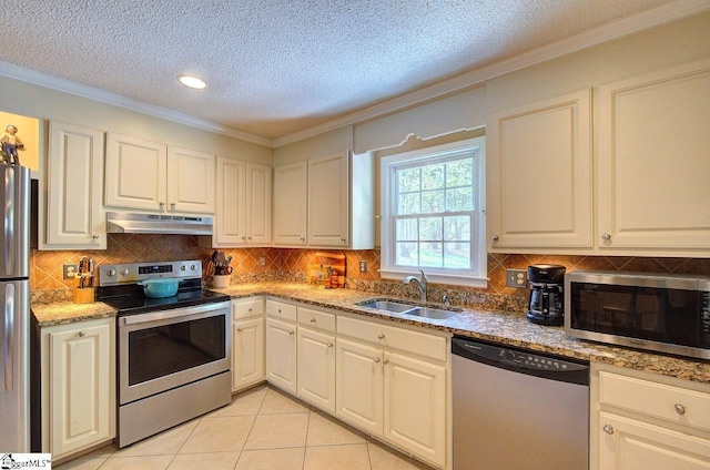 kitchen featuring crown molding, a sink, a textured ceiling, stainless steel appliances, and under cabinet range hood
