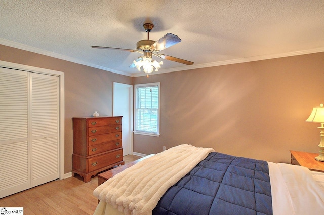 bedroom featuring a ceiling fan, a closet, light wood finished floors, and a textured ceiling