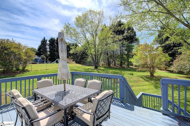 wooden terrace with a yard and outdoor dining area
