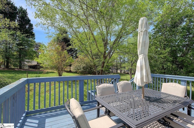 wooden deck with a lawn and outdoor dining space