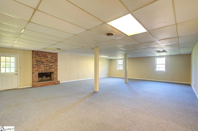 below grade area with a fireplace, carpet flooring, and a paneled ceiling
