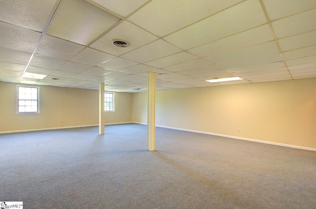 below grade area featuring baseboards, carpet, a drop ceiling, and visible vents