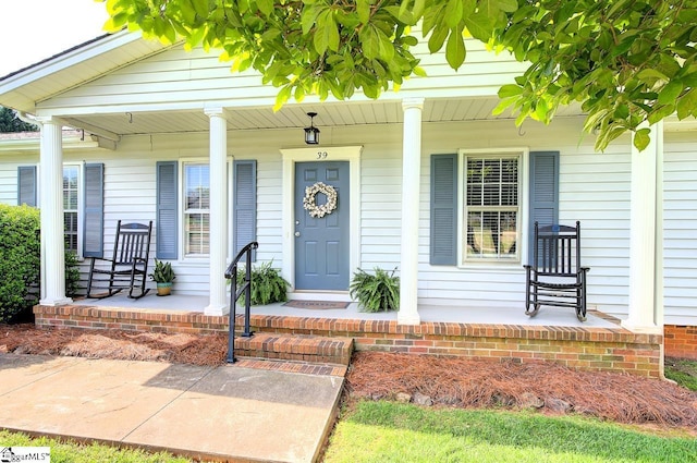 view of exterior entry featuring covered porch