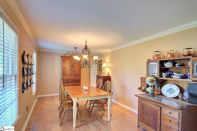 dining room featuring a textured ceiling, an inviting chandelier, baseboards, and light wood-style floors