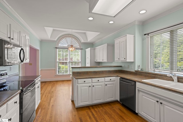 kitchen featuring white cabinets, crown molding, dark countertops, stainless steel dishwasher, and black range with electric stovetop