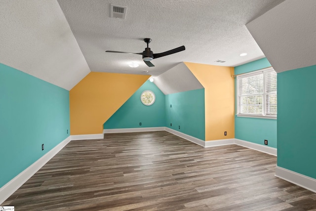 additional living space with a textured ceiling, ceiling fan, visible vents, and wood finished floors