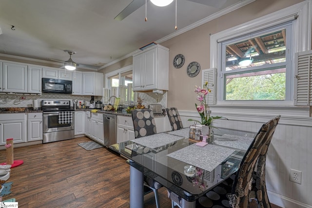 kitchen featuring crown molding, dark wood-style flooring, appliances with stainless steel finishes, and ceiling fan