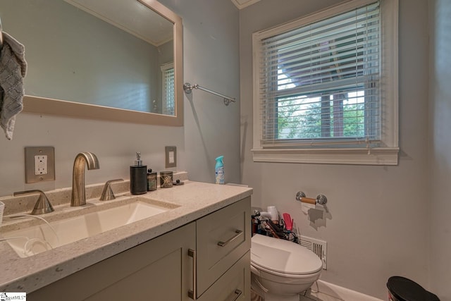 bathroom featuring toilet, ornamental molding, and vanity