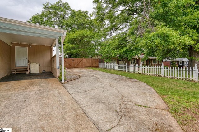 view of patio featuring a gate, fence private yard, entry steps, and a carport