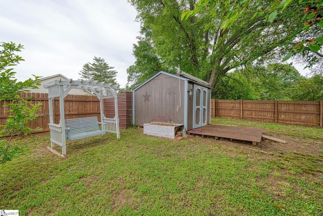 view of yard featuring an outdoor structure, a pergola, a fenced backyard, and a storage unit