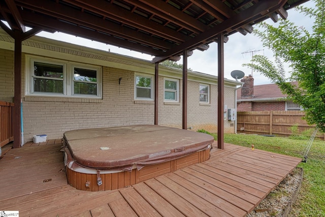 deck featuring hot tub deck surround and fence
