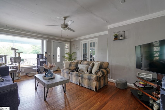 living room with a ceiling fan, baseboards, ornamental molding, and wood finished floors