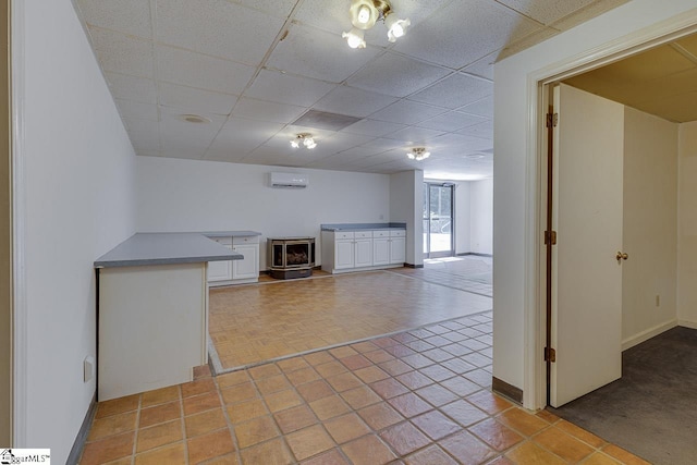 118 Pine Ln, Simpsonville, SC 29681 - interior space with baseboards, a drop ceiling, a wood stove, and a wall mounted air conditioner
