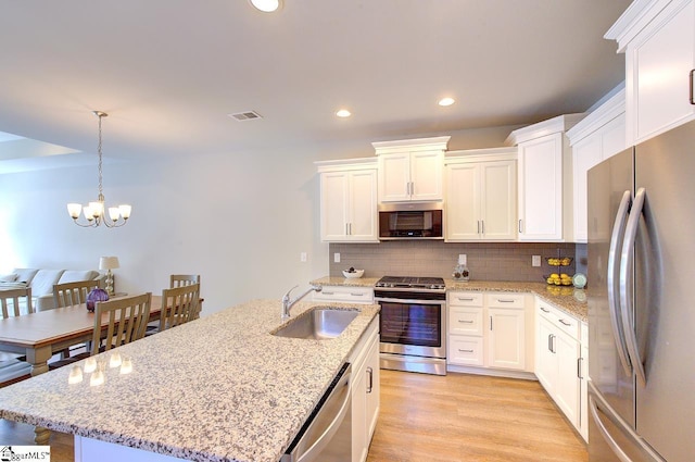 kitchen featuring white cabinets, appliances with stainless steel finishes, a sink, and visible vents