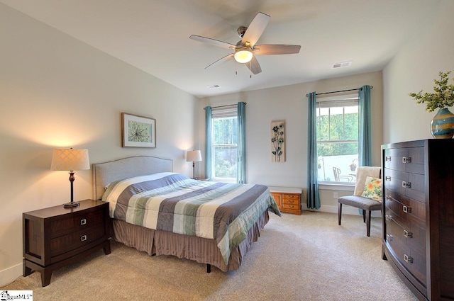bedroom with visible vents, baseboards, ceiling fan, and light carpet