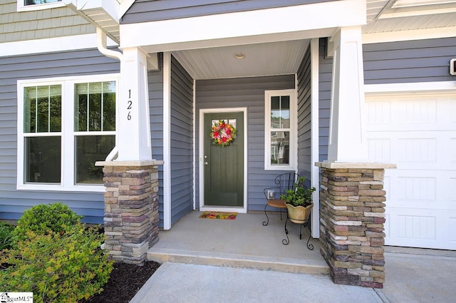 entrance to property featuring a garage and covered porch