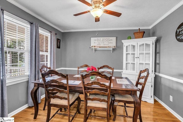dining space featuring a ceiling fan, baseboards, and light wood-type flooring