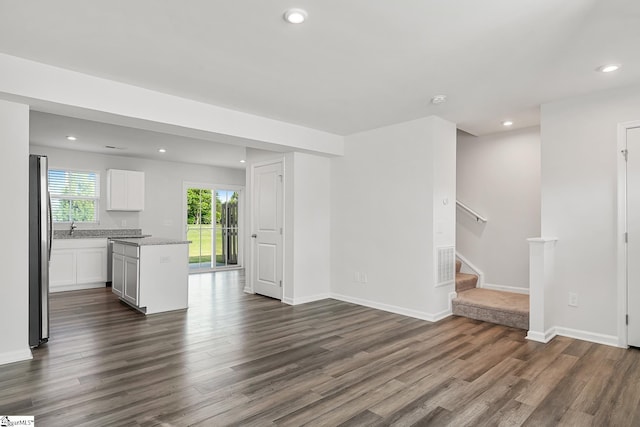 unfurnished living room featuring recessed lighting, dark wood-style flooring, stairs, and visible vents