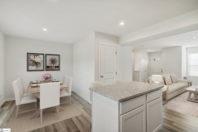 kitchen with a kitchen island, recessed lighting, open floor plan, and light wood-style flooring