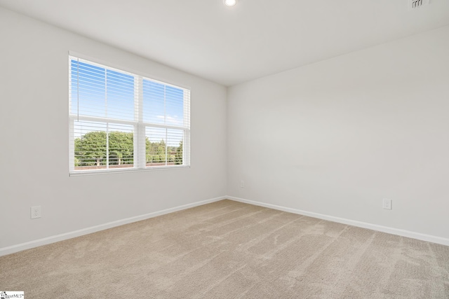 unfurnished room featuring recessed lighting, baseboards, light colored carpet, and visible vents