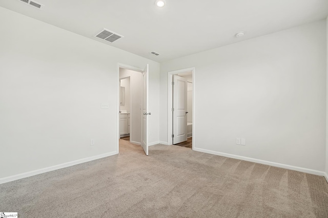 unfurnished bedroom with carpet flooring, baseboards, and visible vents