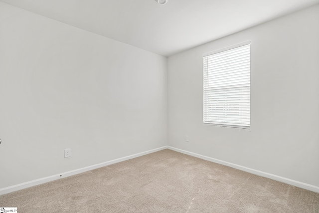 empty room featuring carpet flooring and baseboards