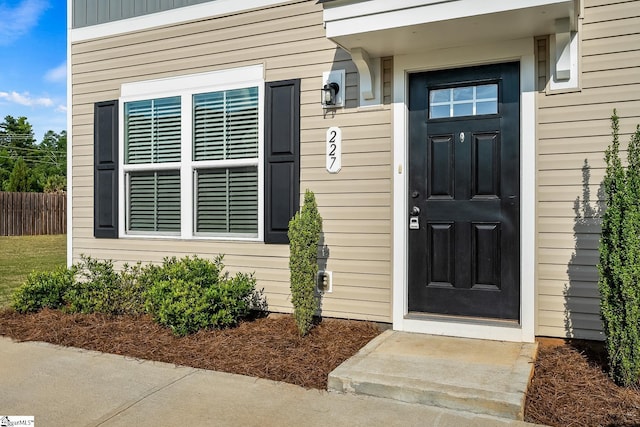 doorway to property featuring fence