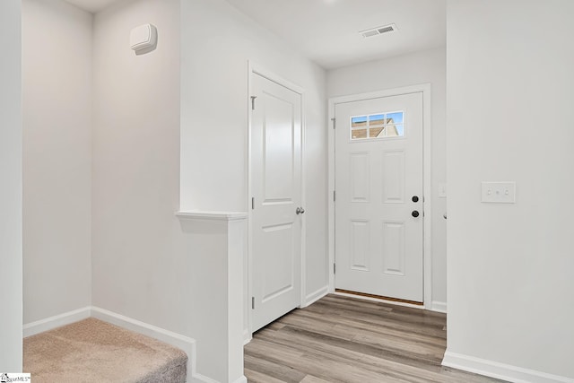interior space featuring baseboards, visible vents, and light wood-type flooring