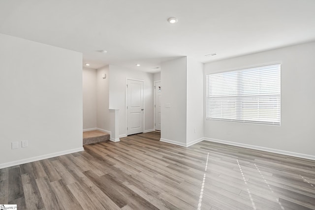 spare room with recessed lighting, baseboards, and wood finished floors