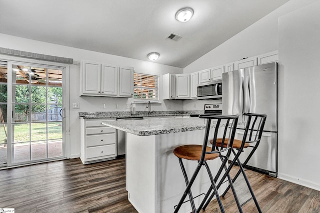 232 Ashley Danielle Dr, Duncan, SC 29334 - kitchen with visible vents, lofted ceiling, a breakfast bar, dark wood finished floors, and stainless steel appliances