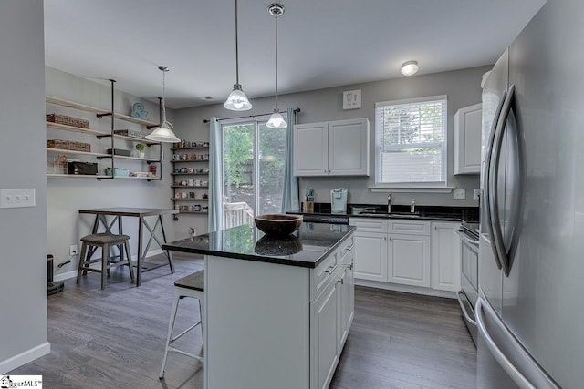 kitchen with a breakfast bar area, stainless steel appliances, plenty of natural light, and white cabinetry