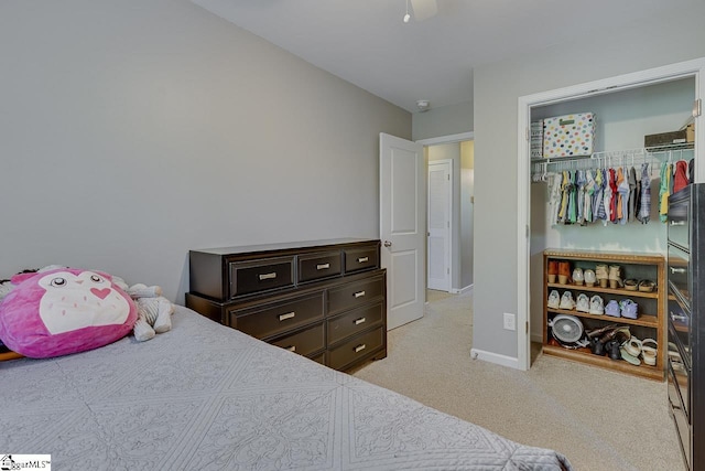 bedroom featuring a ceiling fan, baseboards, light carpet, and a closet