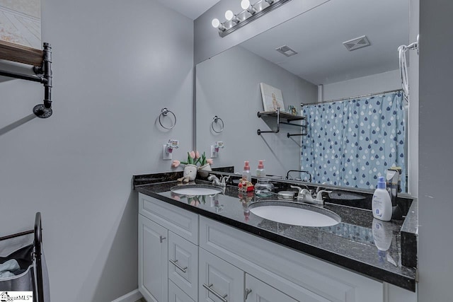 full bath featuring visible vents, a sink, and double vanity