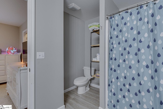 full bathroom with visible vents, wood finished floors, baseboards, toilet, and a shower with shower curtain