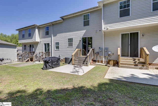 back of house featuring entry steps, central AC unit, a yard, and a patio