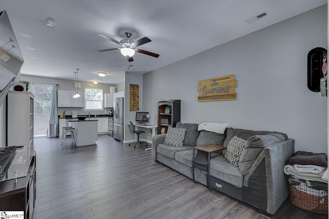 living area with ceiling fan, dark wood-style flooring, and visible vents
