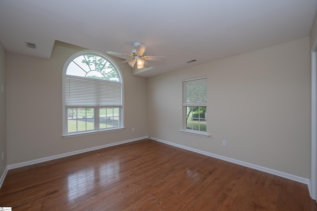empty room with visible vents, baseboards, ceiling fan, and wood finished floors